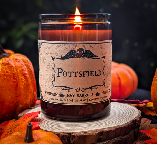 Pottsfield candle inspired by Over the Garden Wall, with pumpkin, hay barrels, and nutmeg fragrance in an amber glass jar.